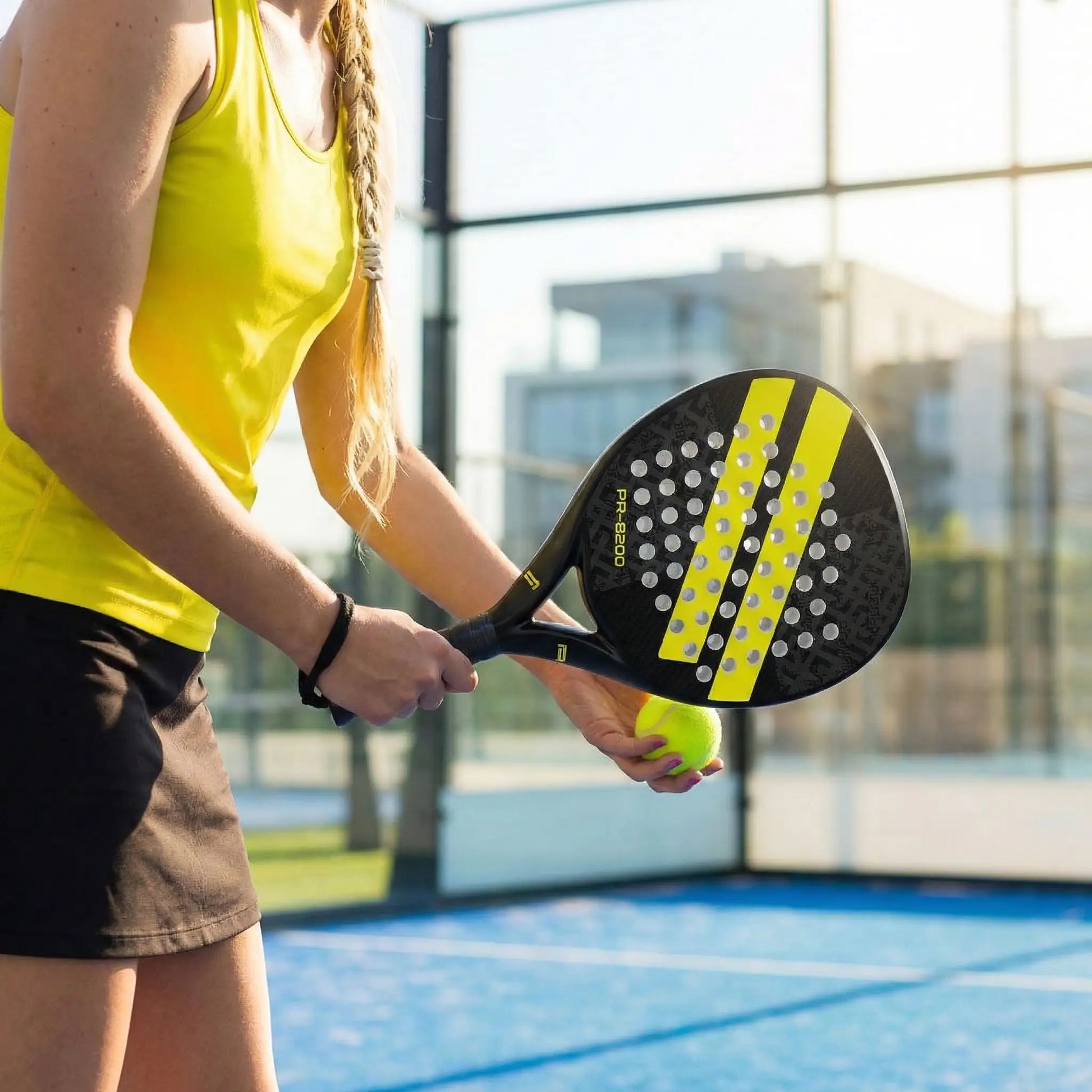Femme joue au padel avec raquette padel jaune