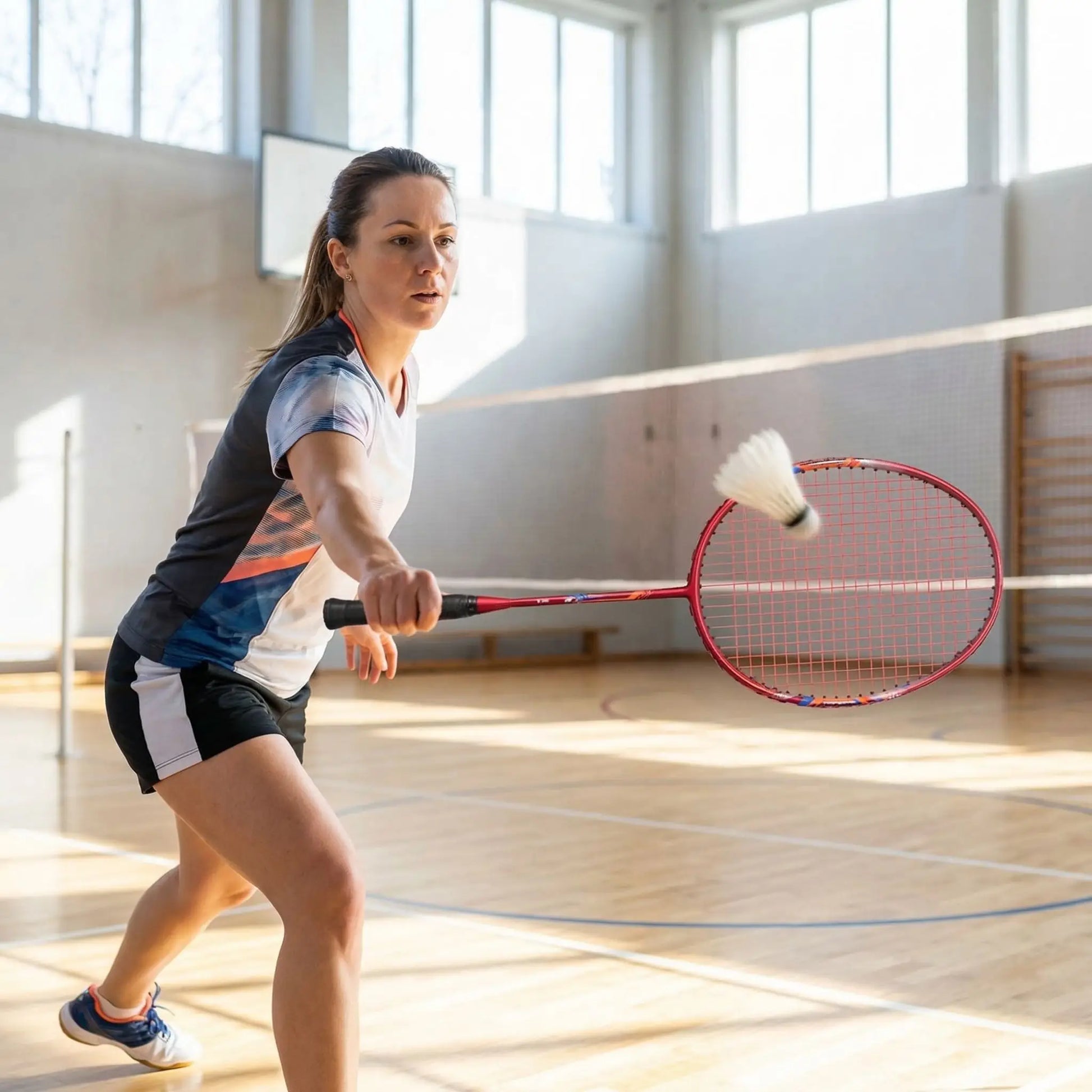 Femme raquette badminton rouge gymnase