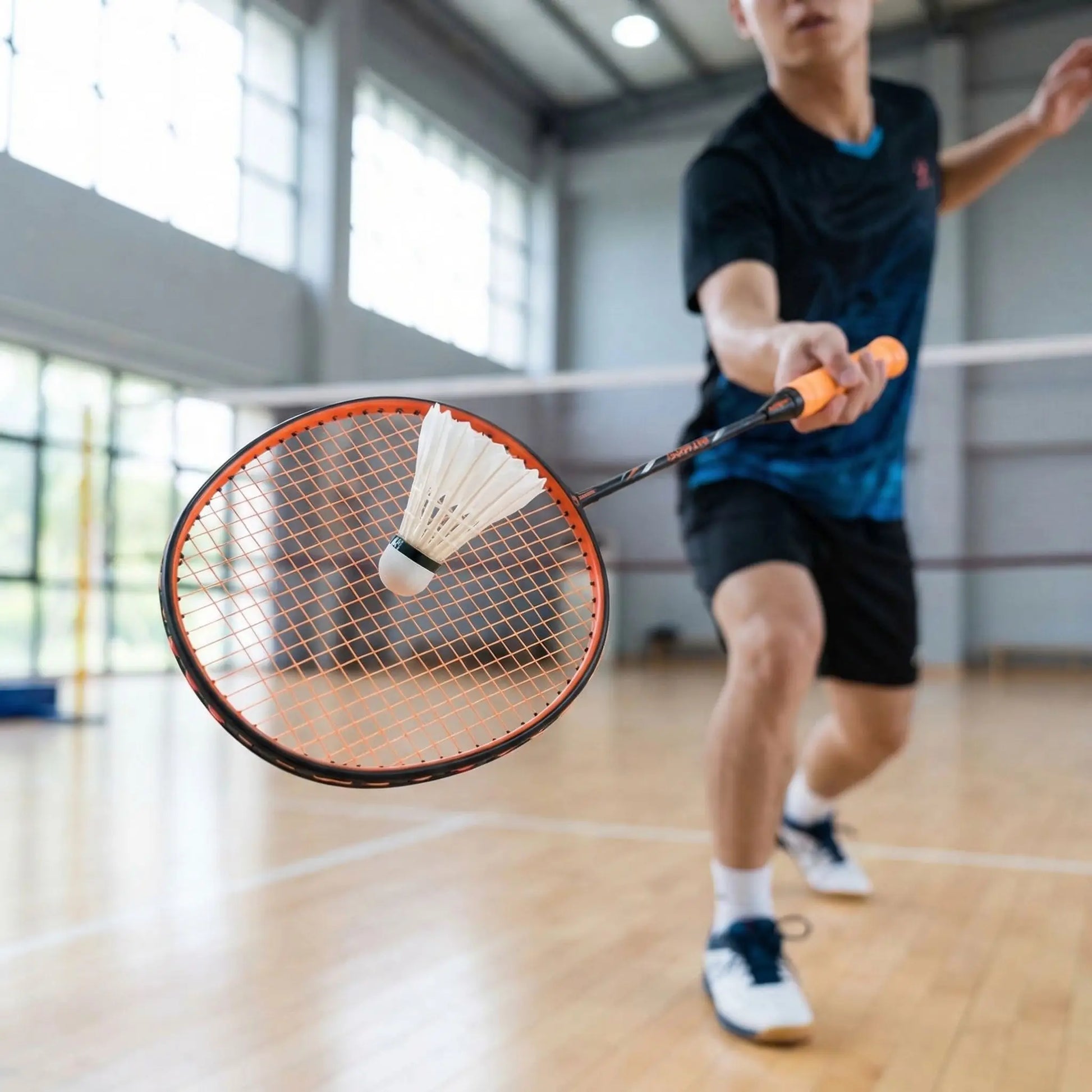 Homme avec raquette de badminton au gymnase