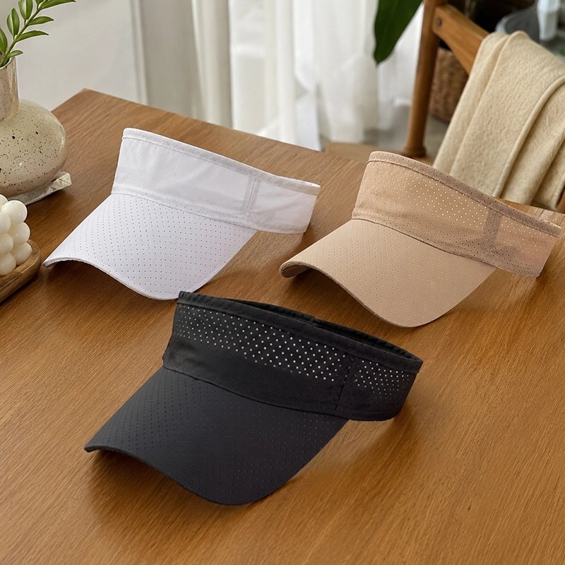 Casquette à visière blanche beige et noire sur une table