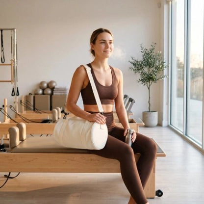 Femme assise chez elle avec son petit sac de sport en bandoulière