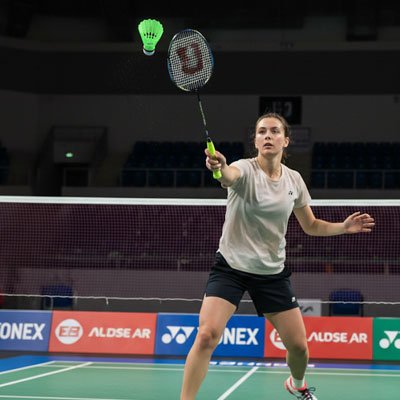 Femme fait une touche avec son volant badminton 