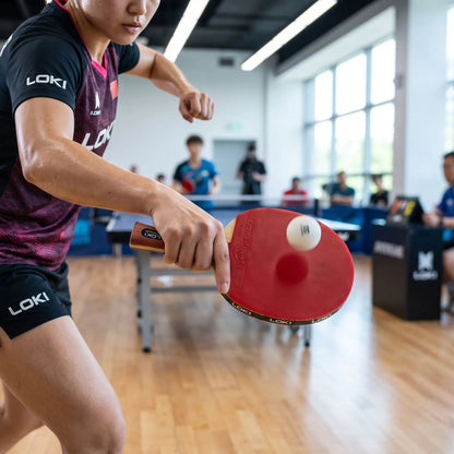 Femme frappe une balle avec sa raquette ping pong 10 étoiles