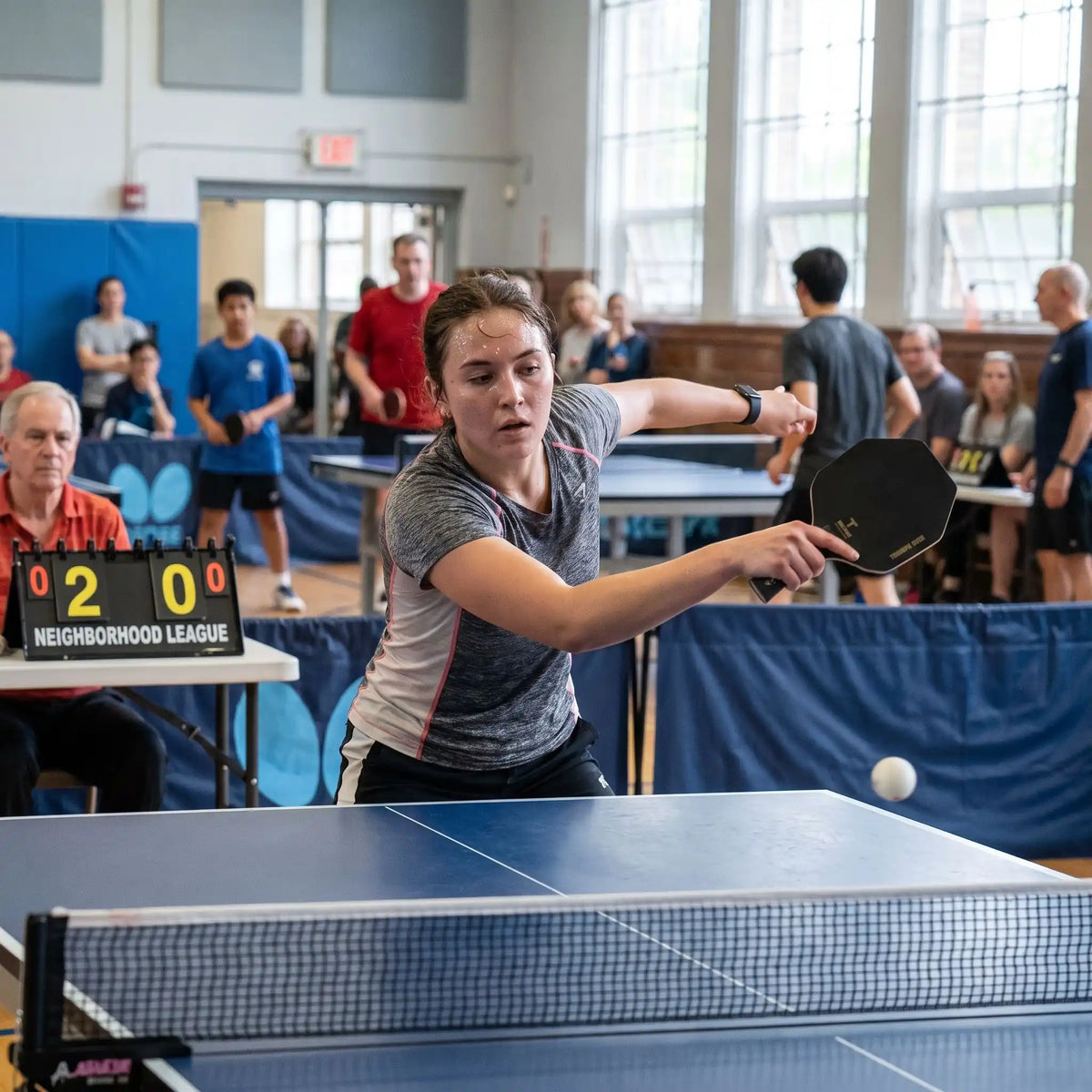 Femme joue dans une ligue avec sa raquette ping pong hexagonale