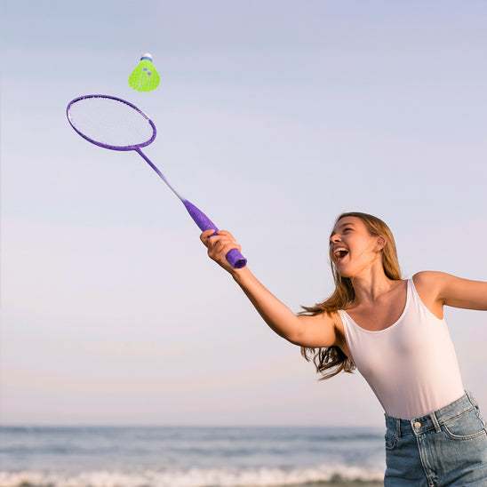 femme plage joue badminton avec raquette badminton