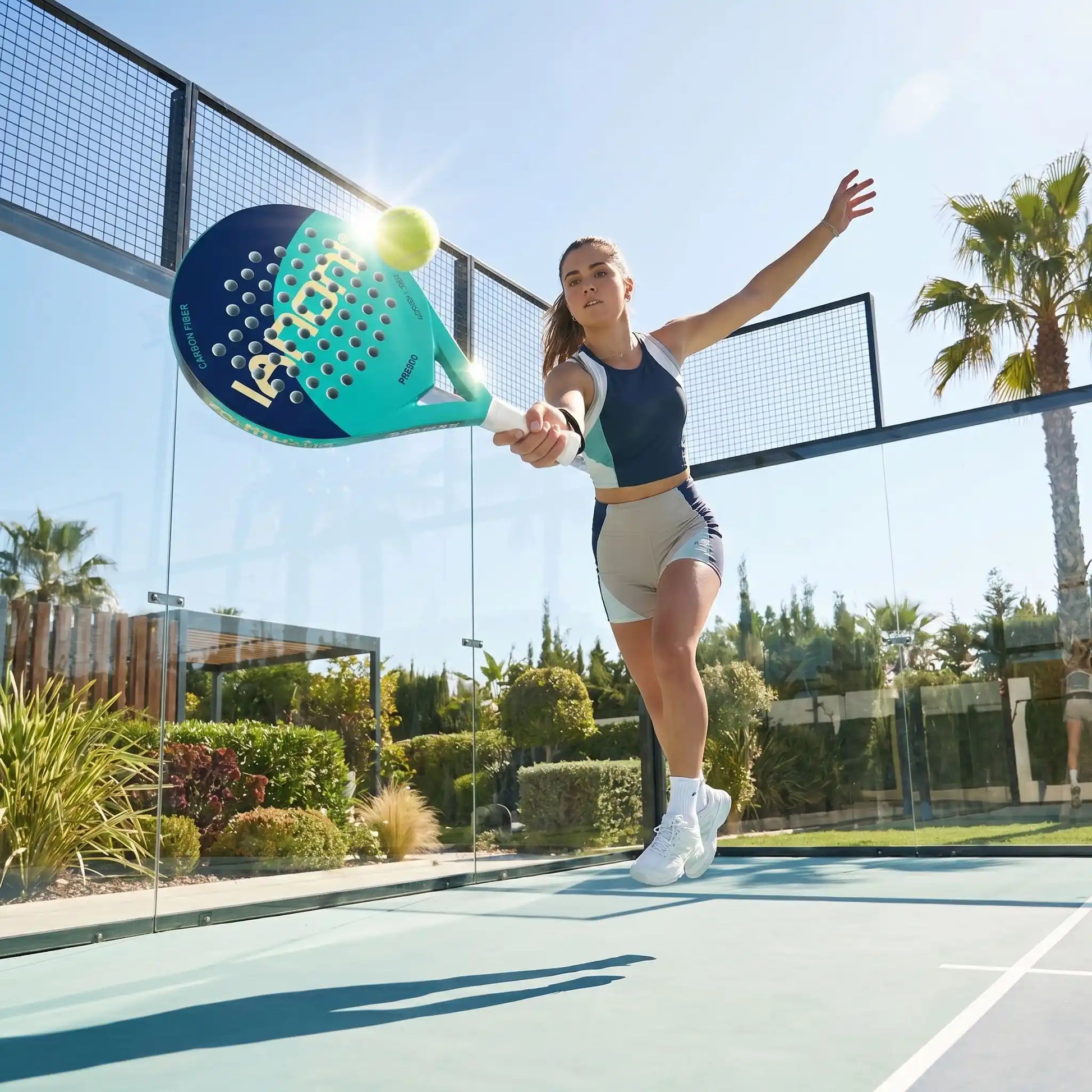 Femme saute dans les airs avec raquette de padel