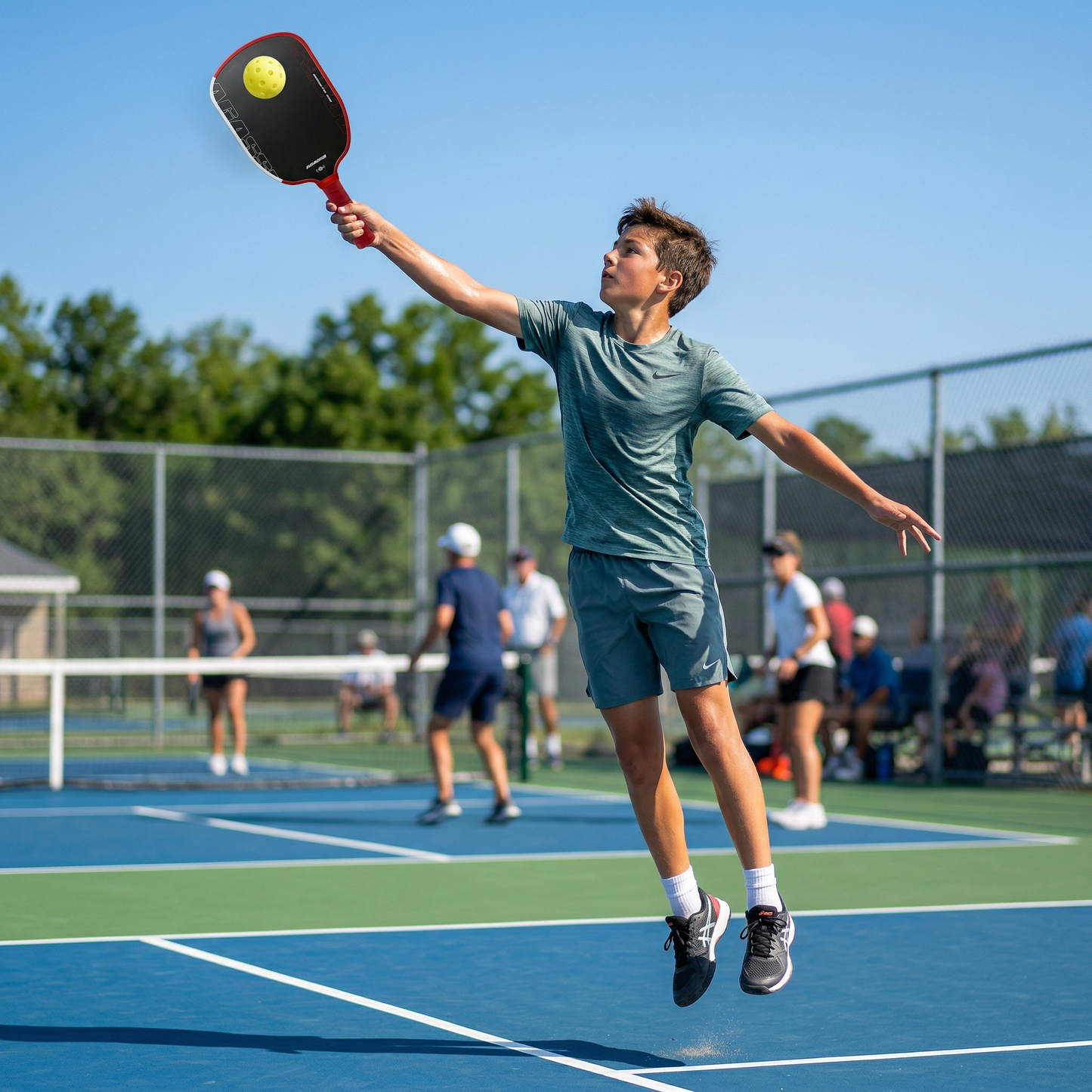 Garcon saute avec pickleball raquette