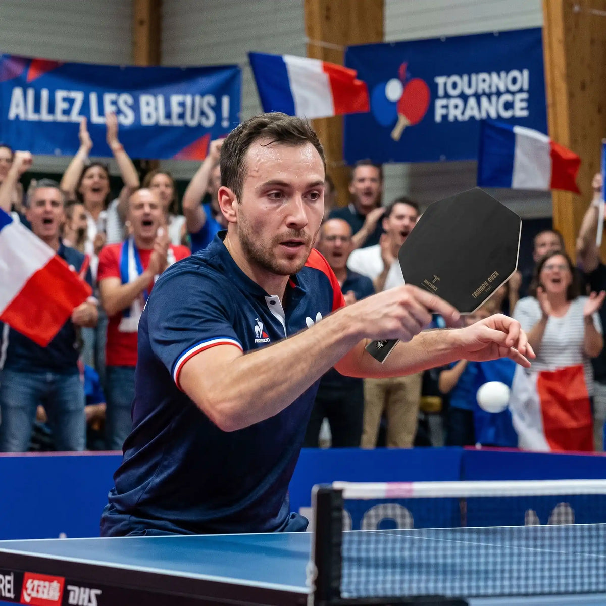Homme dans un tournoi pro joue avec sa raquette ping pong hexagonale