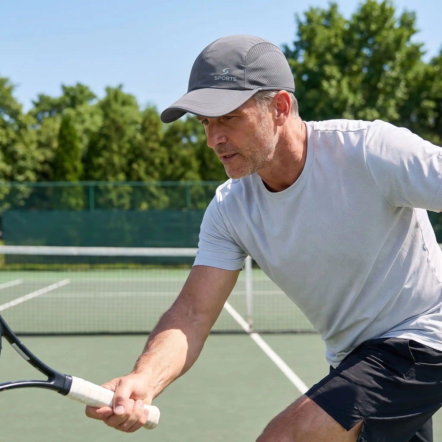Homme fait un coup droit avec casquette tennis